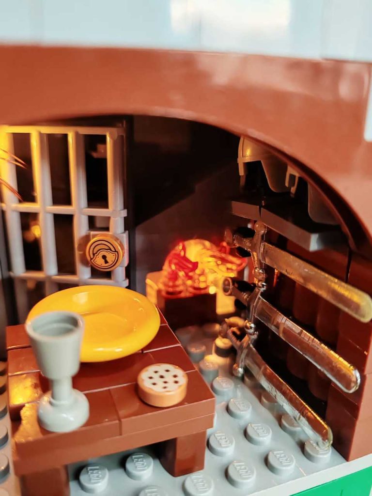 Lego model of Castell Coch's interior with fire and selection of swords